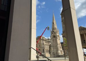 High-level cleaning on a historic monument using specialist equipment in a city centre setting