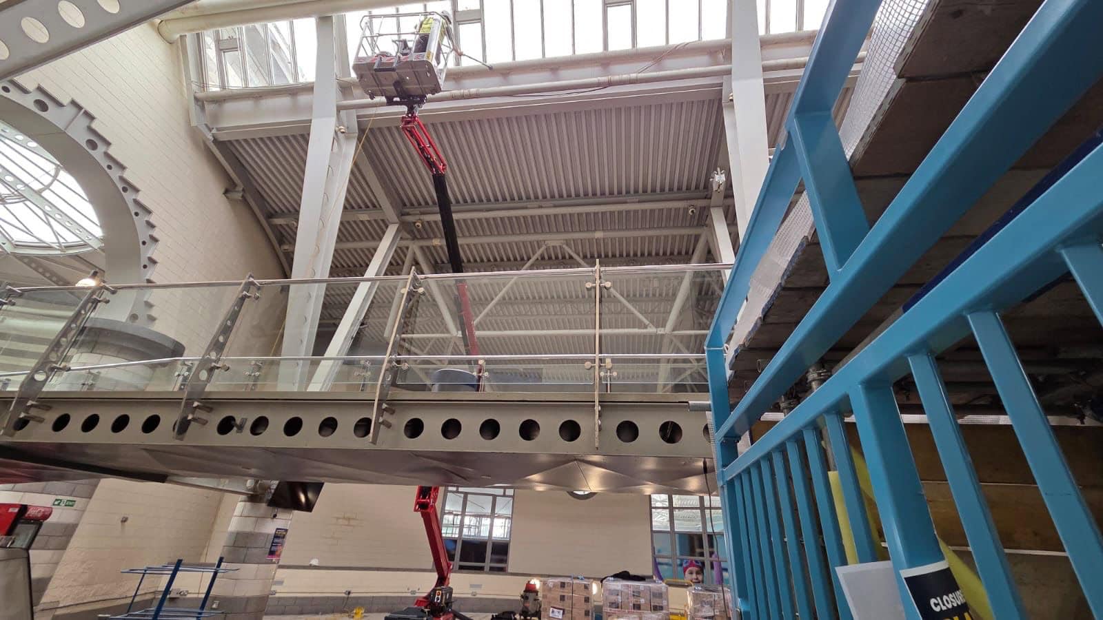 High-Level Dust Removal Inside of The Dome Leisure Centre in Doncaster which is undergoing a refurbishment. Cherry picker being used by Brooklands Group to access the high-level pipes and window sills to remove dust