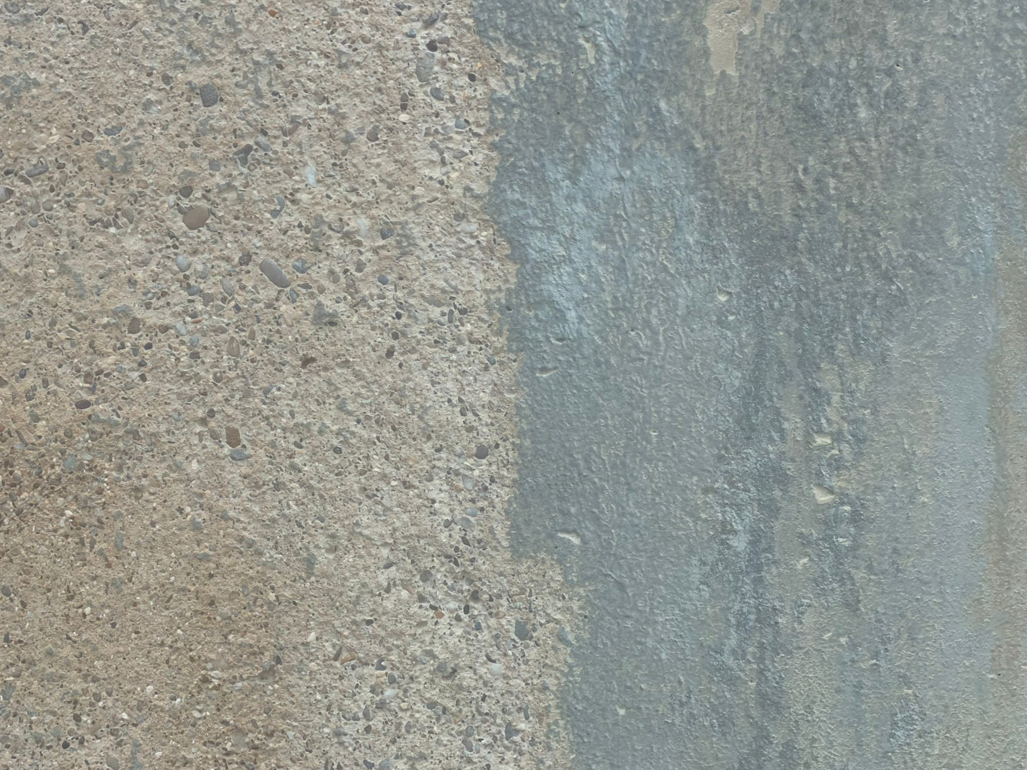 Image shows a close up of the difference on an industrial stone surface after Abrasive blast Cleaning 