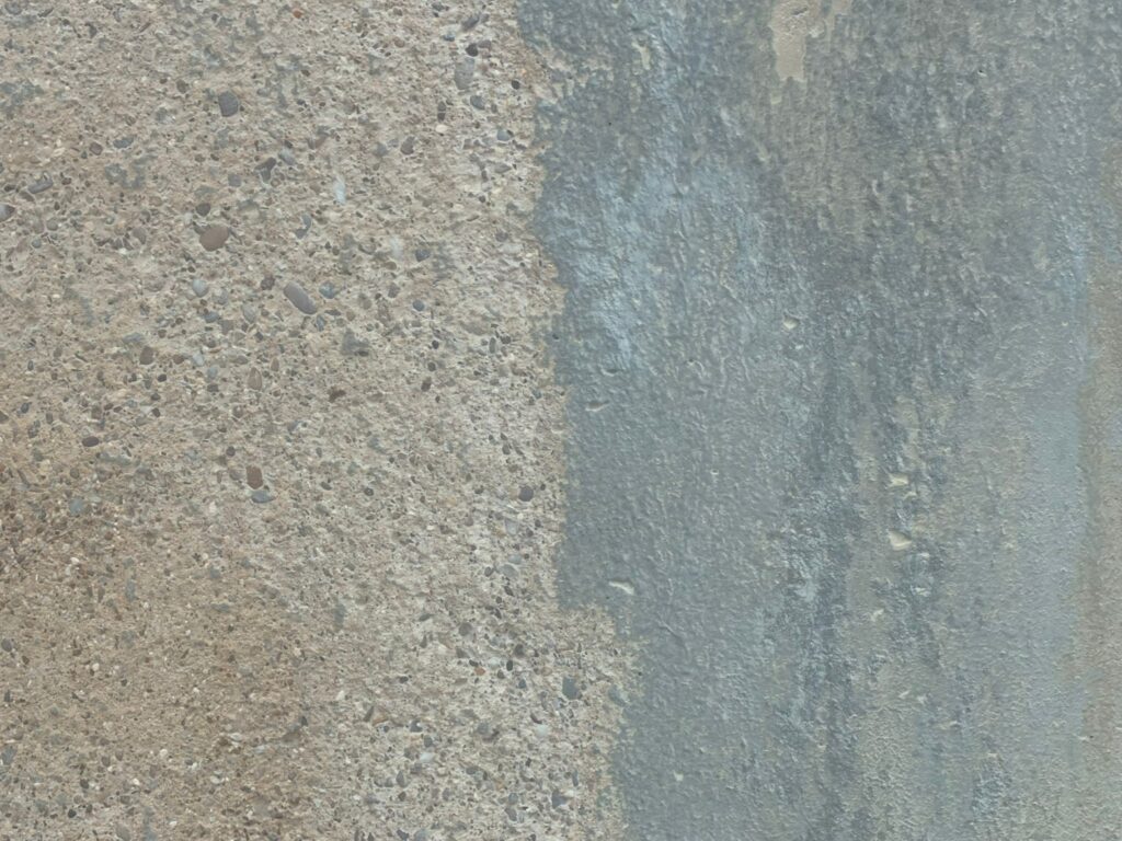 Image shows a close up of the difference on an industrial stone surface after Abrasive blast Cleaning 